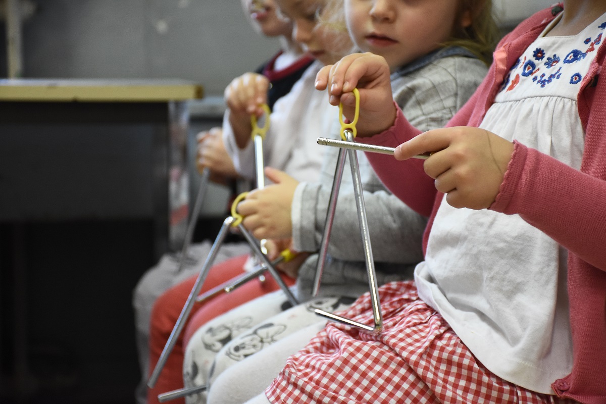 Des enfants entrain de jouer du triangle