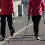 Deux personnes de dos marchent avec des bâtons dans les mains